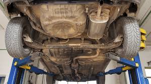 Rusty vehicle underbody showing corrosion before undercoating inspection